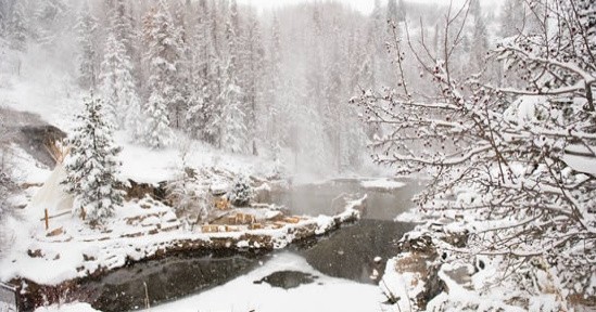 Strawberry Hot Springs Admission & Shuttle Transportation Image 1 a waterfall with trees on the side of a snow covered slope