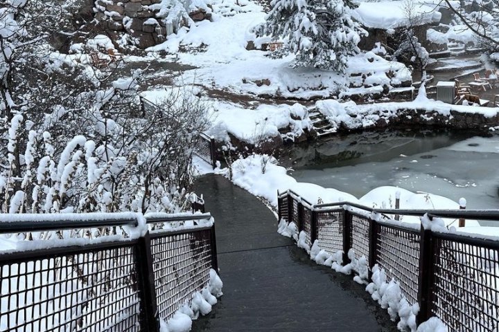 a snow covered bridge across a lake